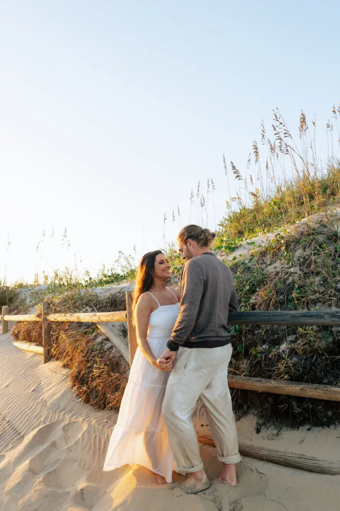An engaged couple in posed portraits at the beach
