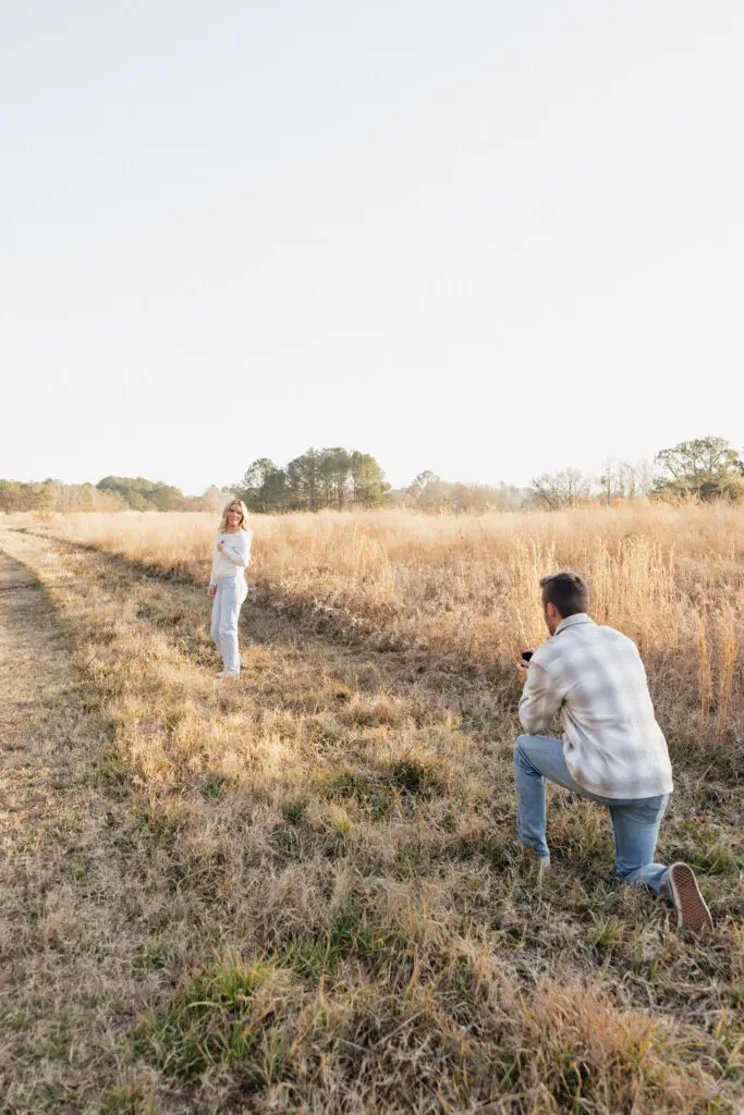 Virginia Beach couple newly engaged at Bells Mills in Chesapeake, photographed in a quiet winter field.

