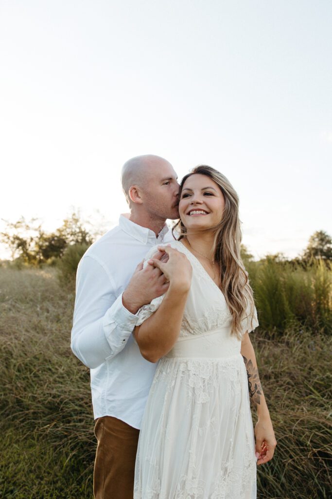 A man kissing his soon to be bride at an engagement session. 
