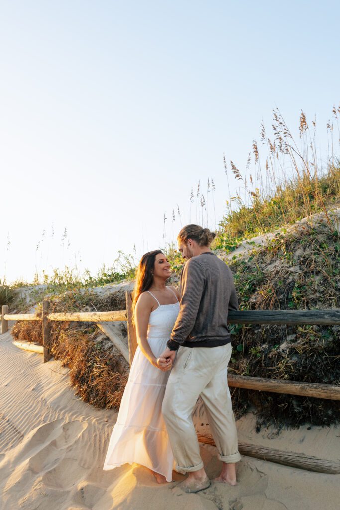 An engaged couple in posed portraits at the beach