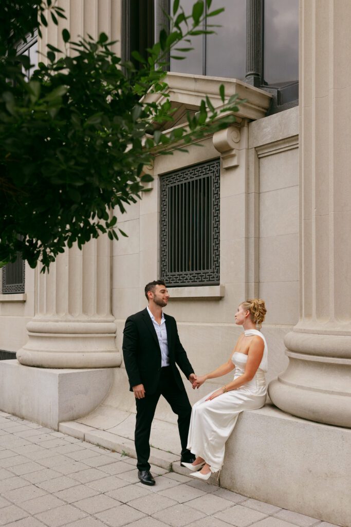 Engaged man and woman staring at one another in downtown city Virginia photoshoot