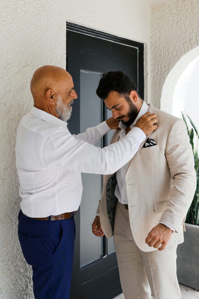 Groom and his dad adjusting suit jacket 