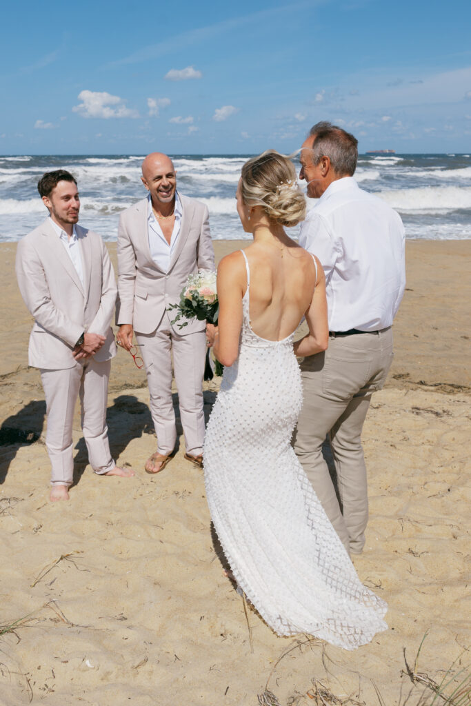 A sunny, mid day small wedding on the sand at Virginia's oceanfront beach. 