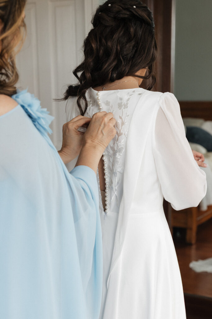 Bride getting her dress put on in the bridal suit at Lovingston Winery near Charlottesville Virginia during wedding getting-ready photos
