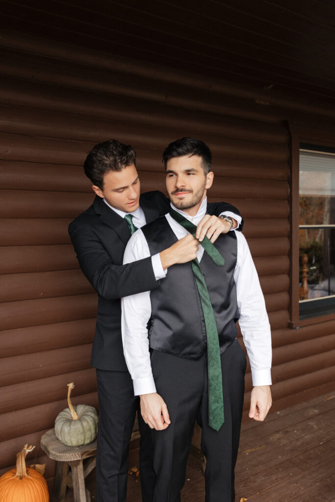 Stunning sunset vineyard wedding groom getting ready among the vines at Lovingston Winery near Charlottesville Virginia in the Virginia mountains