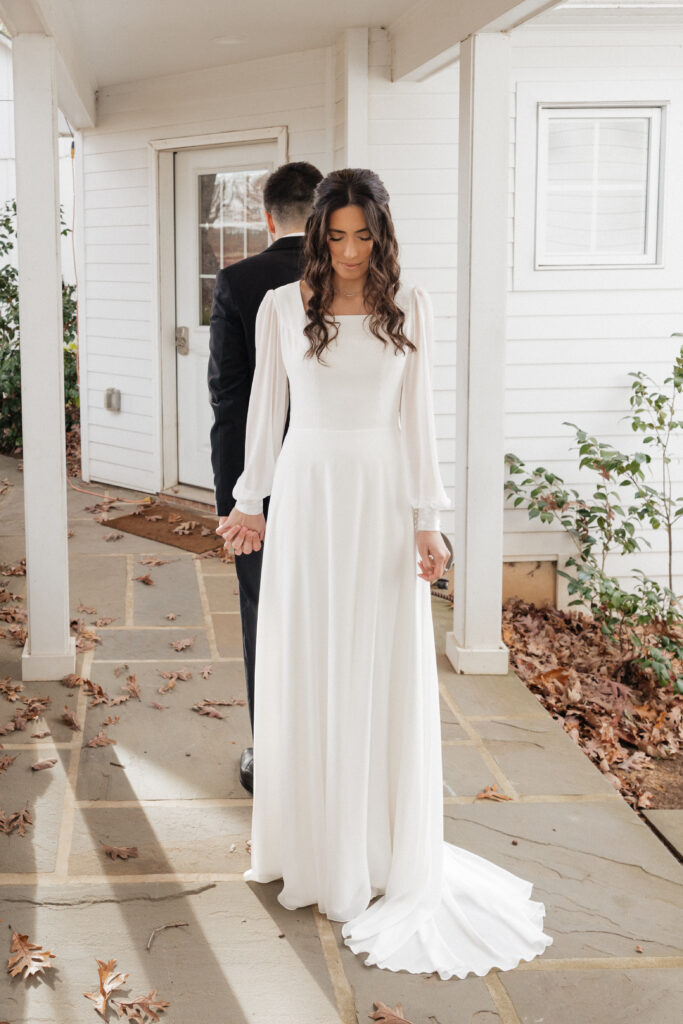 Bride and groom sharing an emotional first look moment among the vineyard rows at Lovingston Winery near Charlottesville Virginia with soft morning light filtering through the vines